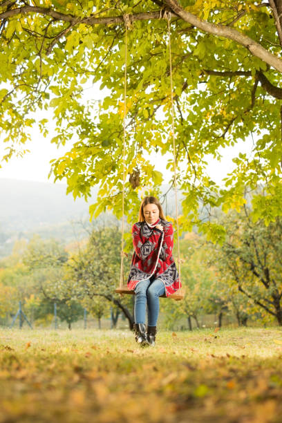 istock Beautiful young woman on a swing 1183454417