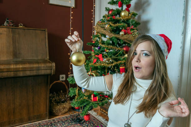 istock Beautiful Woman Decorating a Christmas Tree 1183456748