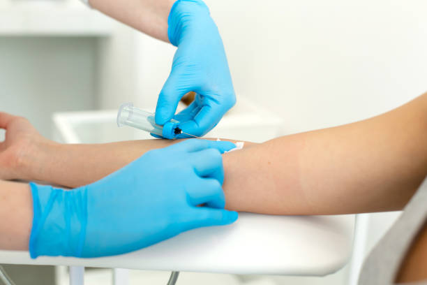 istock a gloved nurse inserts a needle into a vein on the patients arm and draws blood into a vacuum container. Blood sampling procedure 1183456830