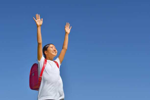 istock Japanese elementary school girl posing in the blue sky 1183461206