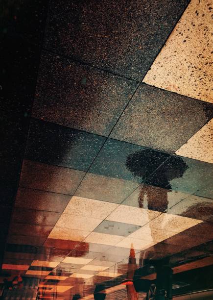 istock Reflection of man walking with umbrella 1183464196