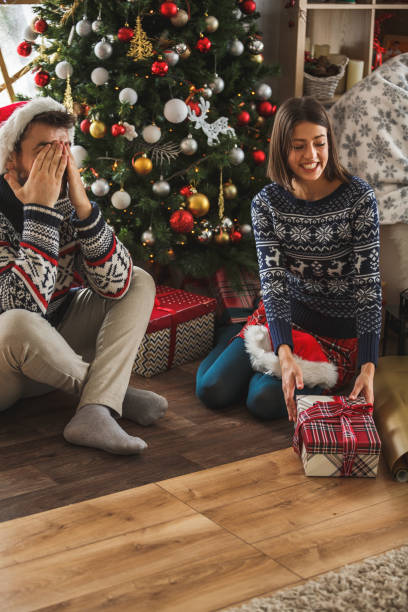istock Man covering eyes while waiting for Christmas present 1183472171
