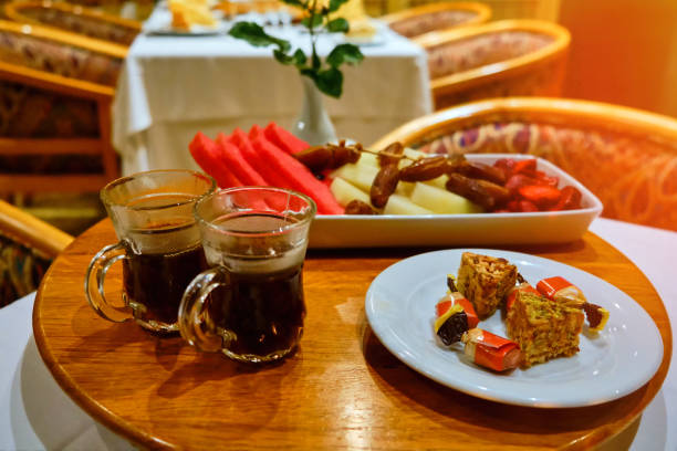istock Oriental sweets, watermelon, dates and tea on plates in an Arabic restaurant 1183472362