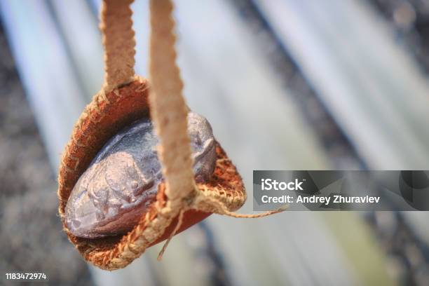 Roman Slingshot Of Leather On The Background Of Chain Mail Vintage