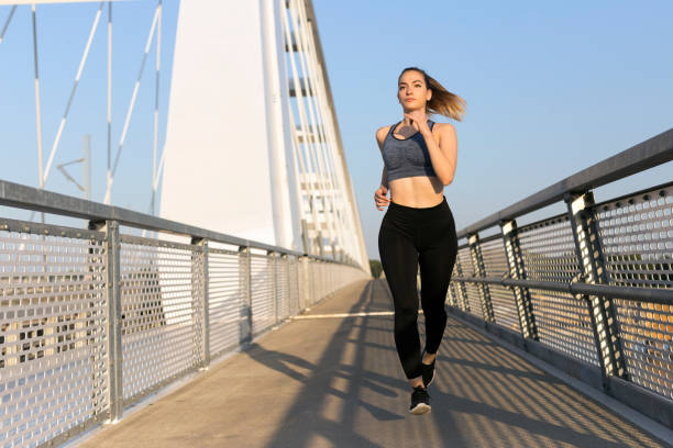 istock Woman jogging over a bridge 1183473601