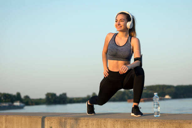 istock Girl with headphones stretching 1183473784