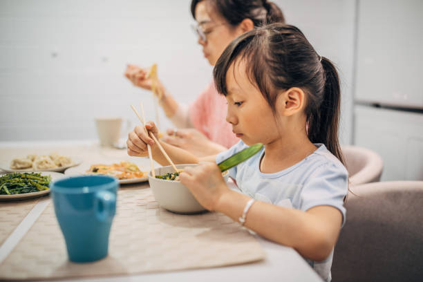 istock Mother and daughter eating together 1183475496