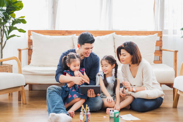 happy asian family using tablet, laptop for playing game watching movies, relaxing at home for lifestyle concept - digital tablet women enjoyment happiness imagens e fotografias de stock