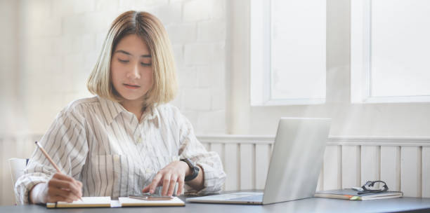 istock Young professional businesswoman working on her project and writing on notebook 1183502127