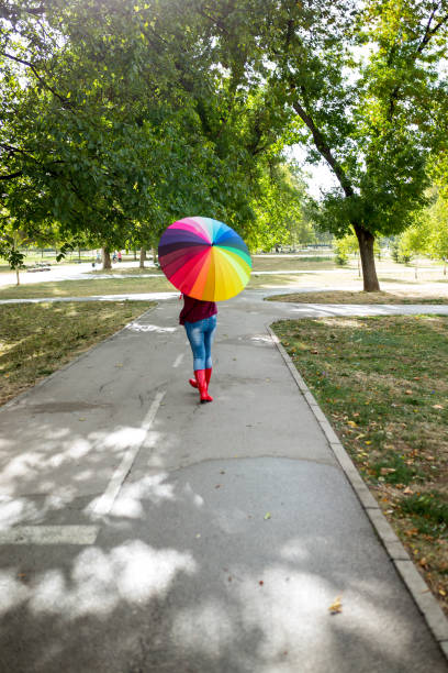istock Beautiful woman under rainbow umbrella 1183502334