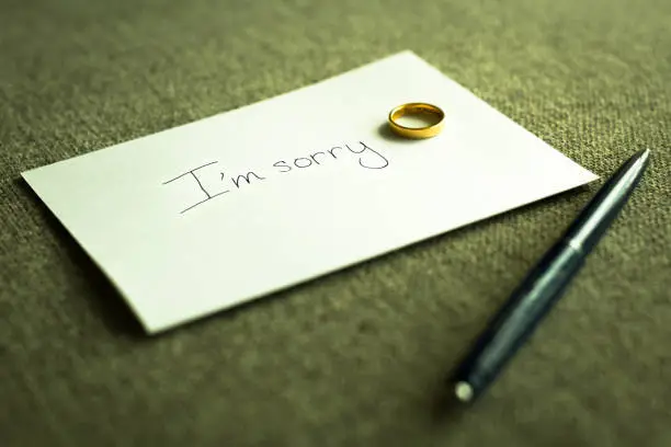 Photo of Marriage separation goodbye note with a wedding ring.