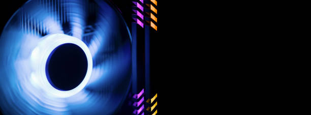 istock Banner. Inside a high performance computer. Rotating fan cooler with colorful  illumination blue.  RAM glows purple and yellow 1183506228