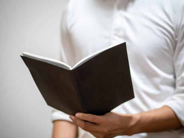 istock man in a shirt holding a black notebook 1183507251
