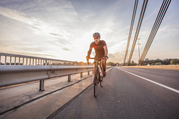 joven montando en bicicleta - speed sports race track cycling vitality fotografías e imágenes de stock