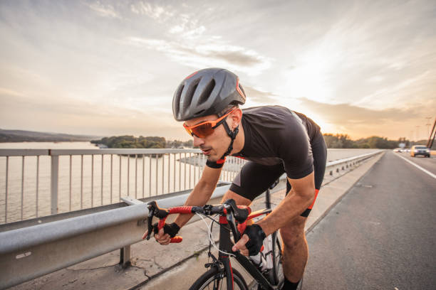 młody człowiek jazda na rowerze na drodze - speed sports race track cycling vitality zdjęcia i obrazy z banku zdjęć