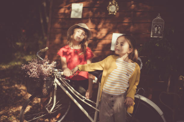 Time for ride with bike. Little girls in garden.