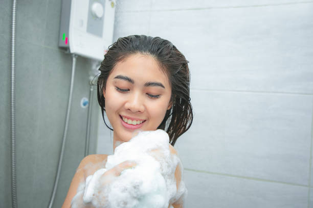 istock Woman taking a shower enjoying foam on her shoulder. 1183514398