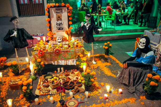 A traditional altar with offerings to the deceased during Dia de Muertos celebrations in Yucatan in southern Mexico Merida, Mexico, November 01 - A traditional "ofrenda", an offering dedicated to the dead with numerous religious images and spiritual symbols during the celebrations of the Day of the Dead, in Merida, Yucatan, in south-eastern Mexico. religious offering stock pictures, royalty-free photos & images