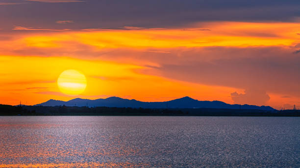 istock Sunset sky and big sun over the lake. 1183518990