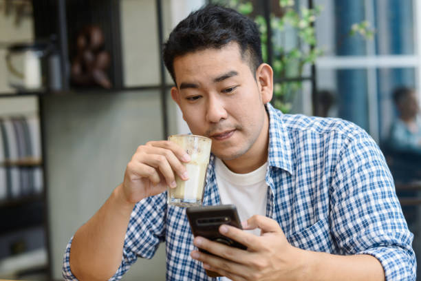 istock Smart Asian man using smartphone in cafe and drinking coffee, lifestyle concept. 1183522738