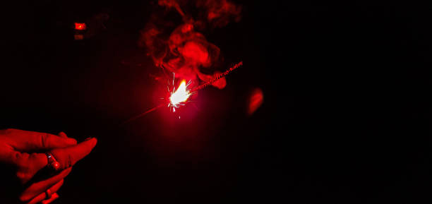 istock Celebration of Diwali with a sparkler  that burns slowly while emitting colored flames, sparks, and other effects. 1183525464