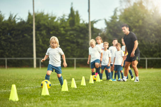 istock Focused Young Footballer Practicing Dribbling around Cones 1183526824