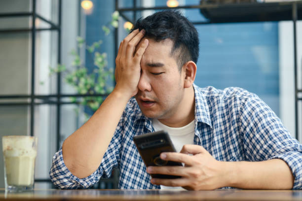 istock Depressed Asian man using smartphone in cafe, lifetyle concept 1183528285