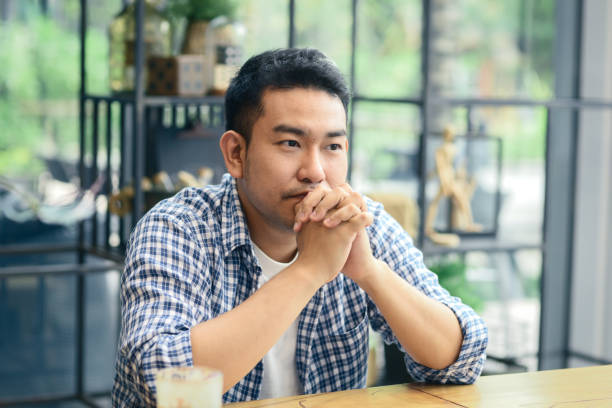 istock Depressed Asian man using smartphone in cafe, lifetyle concept 1183528289