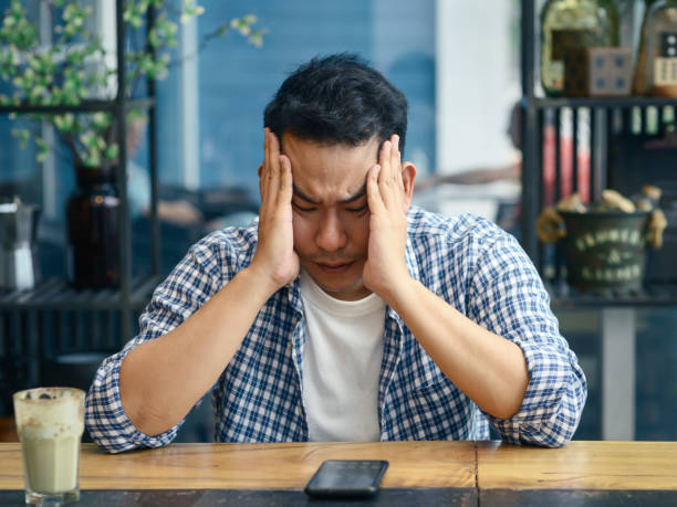istock Depressed Asian man using smartphone in cafe, lifetyle concept 1183528308