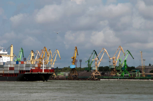 view of working harbor with loading docks and cargo vessel - klaipeda imagens e fotografias de stock