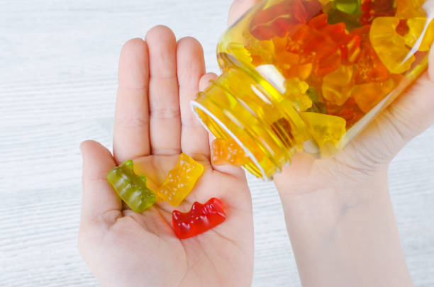 a criança prende vitaminas para miúdos como ursos gummy - gummy - fotografias e filmes do acervo