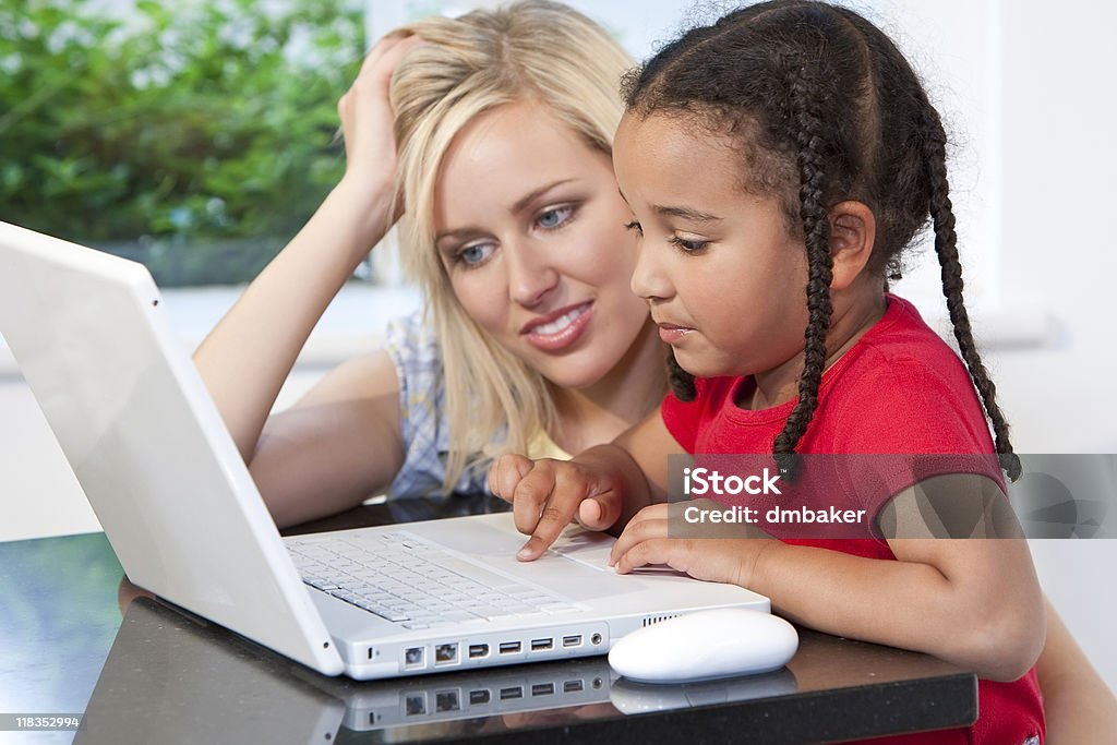 Multiethniques mère et fille à l'aide d'ordinateur portable à la maison - Photo de Adulte libre de droits