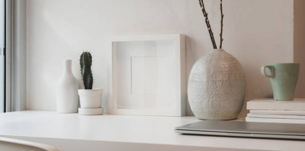 istock Blank white frame and ceramics jar on a white table against the white wall 1183533622
