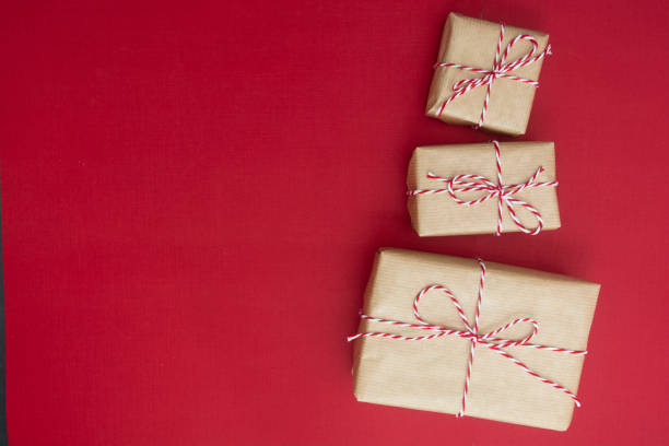 istock Craft gift boxes over red background. Christmas mockup with copy space. winter holidays with presents, top view, flat lay. 1183536017