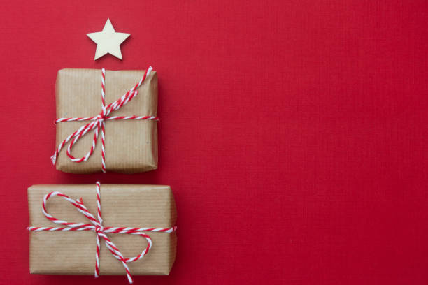 Craft gift boxes over red background. Christmas mockup with copy space. winter holidays with presents, top view, flat lay.