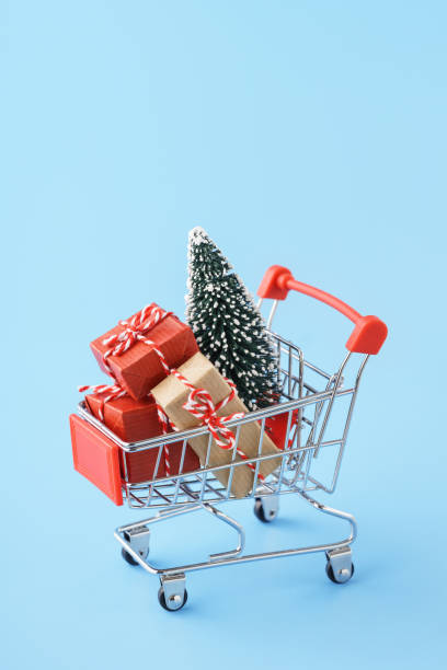 istock Shopping cart full of various gift boxes and a Christmas tree. 1183537459