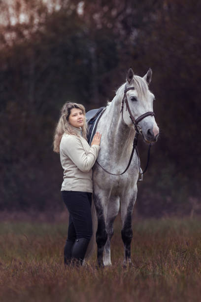istock Beautiful young lady with a purebred arabian stallion 1183539320