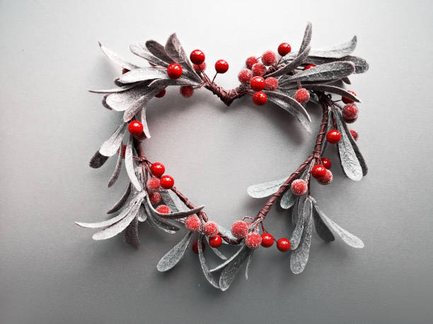 istock Heart-shaped decorative mistletoe Christmas wreath, flat lay on light gradient paper background 1183539378
