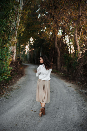 Young woman walking through an autumn road
