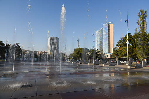 The Place des Nations in Geneva is a city square next to the Palais des Nations. There are several fountains where during summer children are playing. The image was captured during autumn season.
