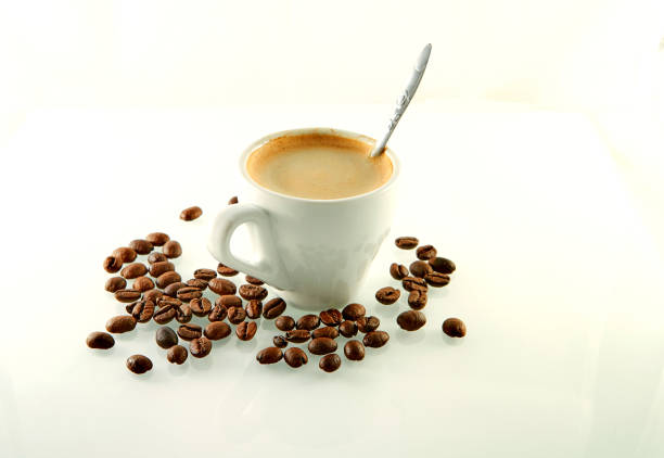 istock Coffee beans around a coffee cup with espresso coffee on a white 1183541186