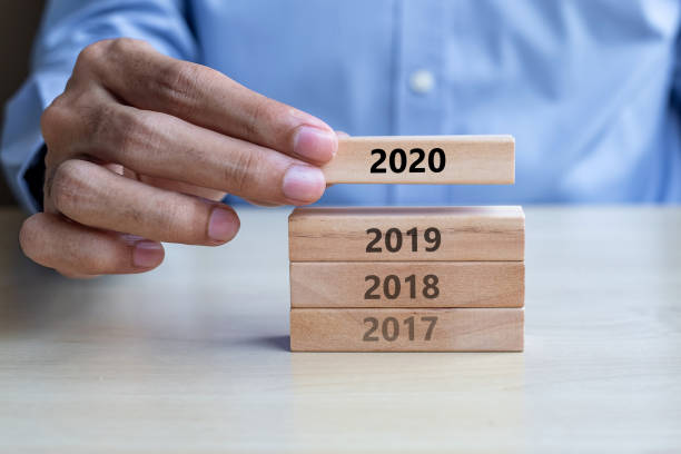 istock Businessman hand pulling 2020 wooden building blocks on table background. Business planning, Risk Management, Resolution, strategy, solution, goal, New Year New You and happy holiday concepts 1183543118