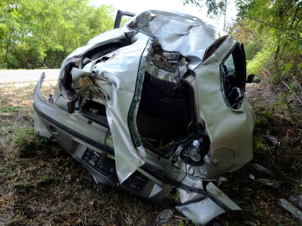 istock wrecked car body on road side after collision. broken wind shield. warped metal 1183543248