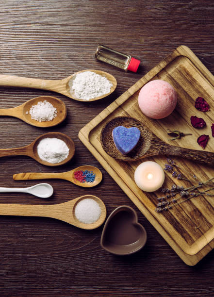istock Making fizzing bath bombs at home concept. All the ingredients on table on wood spoons. Flat lay view. 1183544366