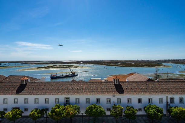 Panoramic view from the tower bell of Faro Cathedral (Church of Santa Maria) with a plane landing at Faro airport, Algarve, Portugal Panoramic view from the tower bell of Faro Cathedral (Church of Santa Maria) with a plane landing at Faro airport. Faro, Algarve, Portugal, April 2019 santa maria california photos stock pictures, royalty-free photos & images