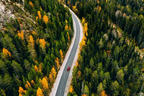 山の秋の色の森の空中写真とフィンランドラップランドの車と道路。 - car winding road highway autumn ストックフォトと画像