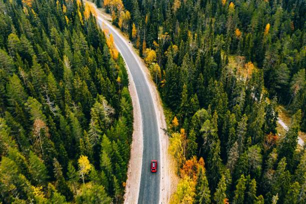 山の秋の色の森の空中写真とフィンランドラップランドの車と道路。 - car winding road highway autumn ストックフォトと画像
