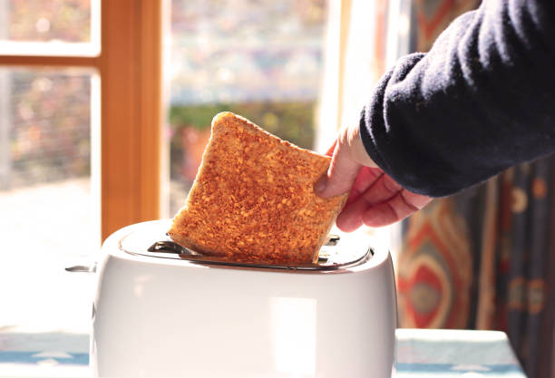 istock hand taking a toast out of a toaster 1183545642