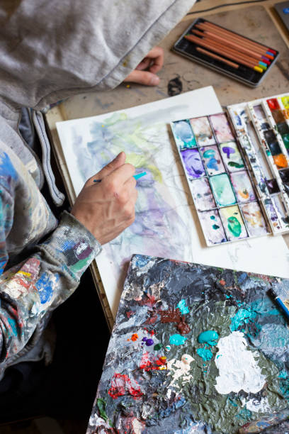 istock Young man painting in his art studio 1183545723