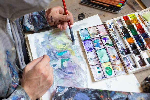 istock Young man painting in his art studio 1183545776